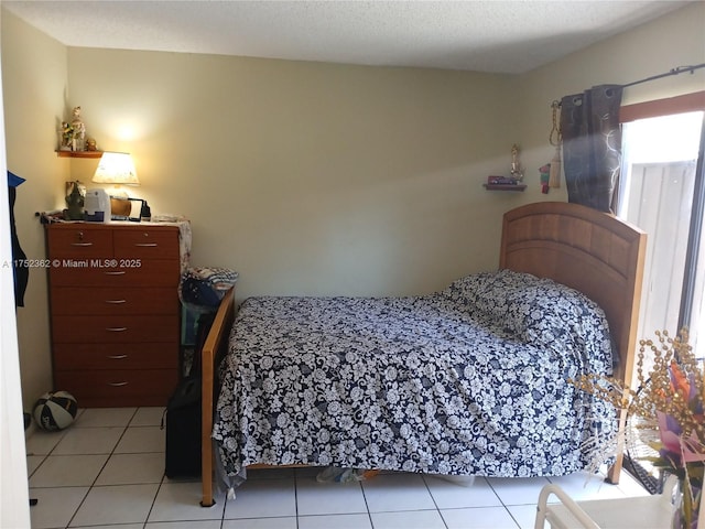 bedroom with light tile patterned floors and a textured ceiling