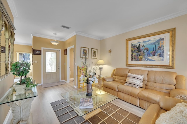 living room featuring light wood-style floors, visible vents, ornamental molding, and baseboards