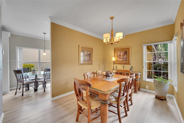 dining space featuring ornamental molding, a chandelier, baseboards, and light wood finished floors