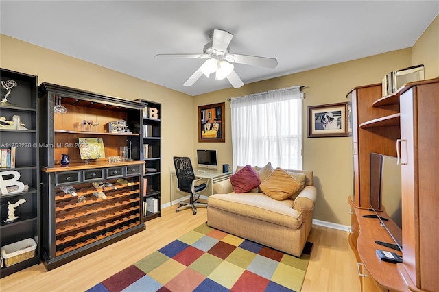 office area featuring baseboards, ceiling fan, and light wood finished floors