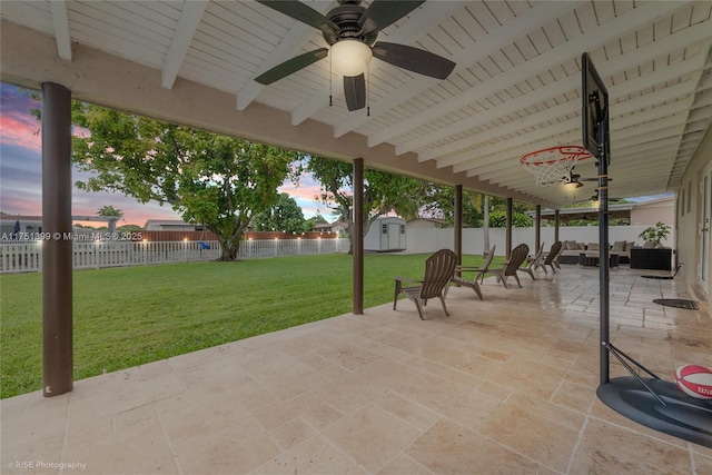 view of patio / terrace with a ceiling fan, an outbuilding, a fenced backyard, and a storage shed