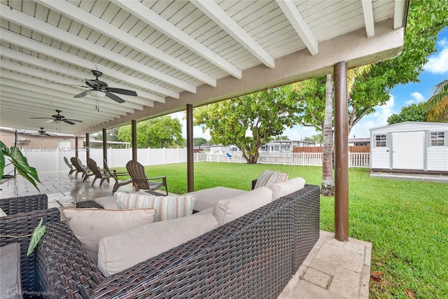 view of patio with a ceiling fan, a fenced backyard, a storage unit, an outdoor structure, and an outdoor living space