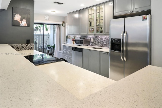 kitchen featuring stainless steel appliances, backsplash, visible vents, and gray cabinetry