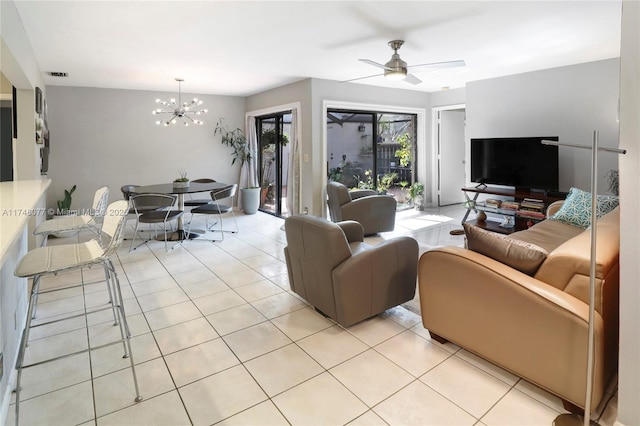 living room featuring light tile patterned floors, visible vents, and ceiling fan with notable chandelier