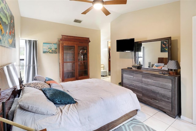 bedroom with lofted ceiling, light tile patterned floors, multiple windows, and visible vents