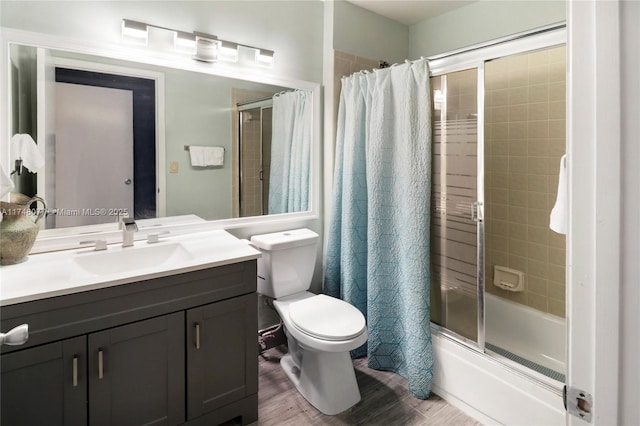 bathroom featuring enclosed tub / shower combo, vanity, toilet, and wood finished floors