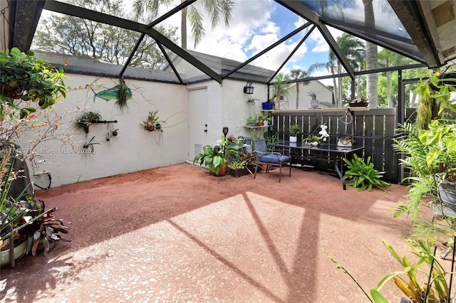 view of patio featuring glass enclosure