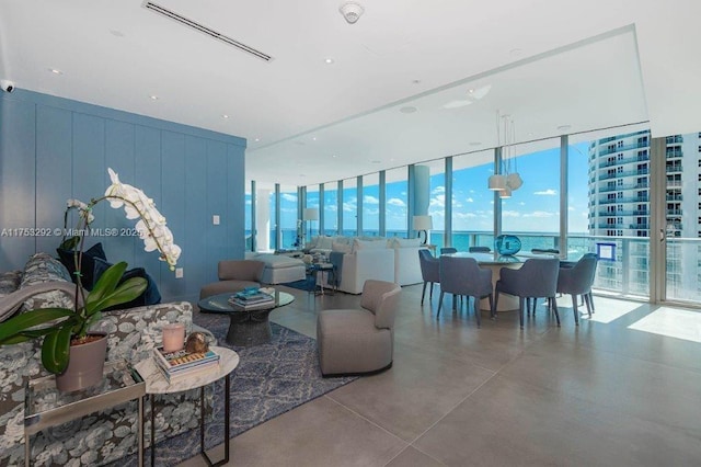 living area with finished concrete flooring, a wall of windows, and visible vents