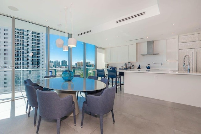 dining room with finished concrete flooring, a view of city, visible vents, and a wall of windows