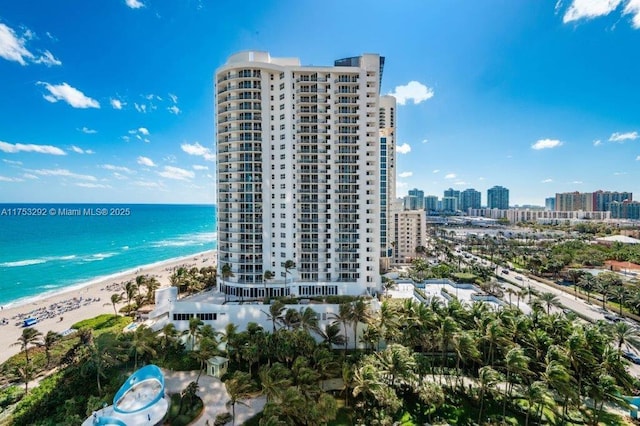 drone / aerial view featuring a beach view, a water view, and a city view