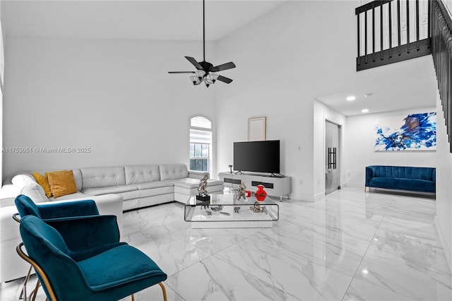 living area featuring recessed lighting, marble finish floor, ceiling fan, and a high ceiling