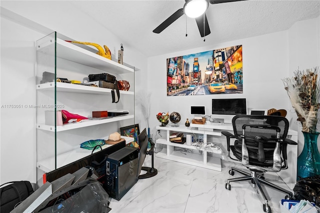 office area featuring marble finish floor, a ceiling fan, and a textured ceiling