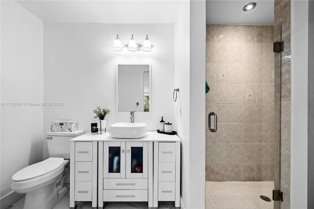 bathroom with a shower stall, toilet, and vanity