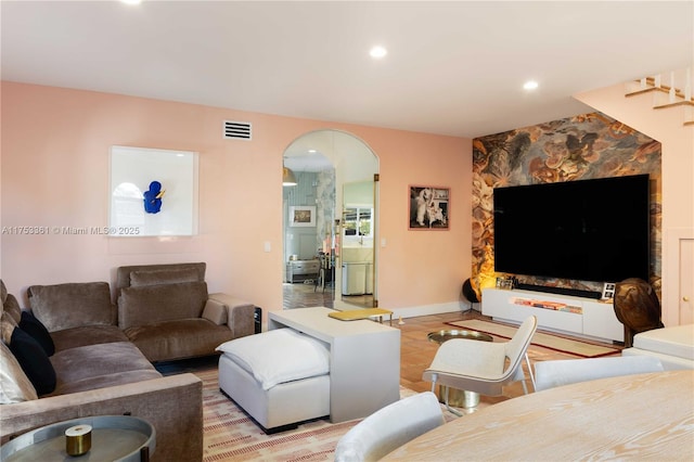 living room with visible vents, arched walkways, baseboards, and recessed lighting