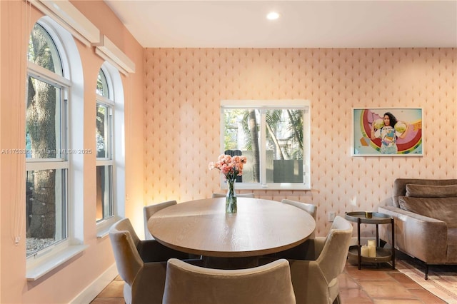 dining room featuring baseboards, a wealth of natural light, and wallpapered walls