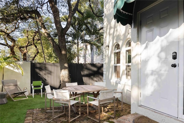 view of patio featuring outdoor dining space and fence