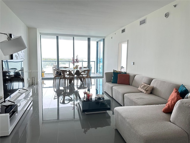 tiled living room with a wall of windows and visible vents