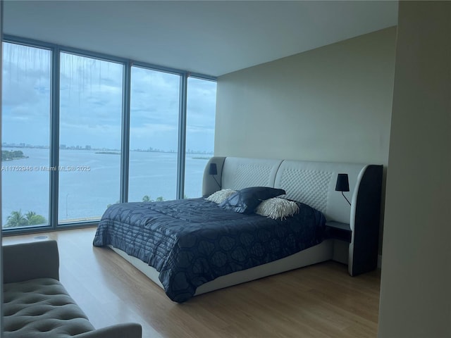 bedroom featuring floor to ceiling windows and wood finished floors