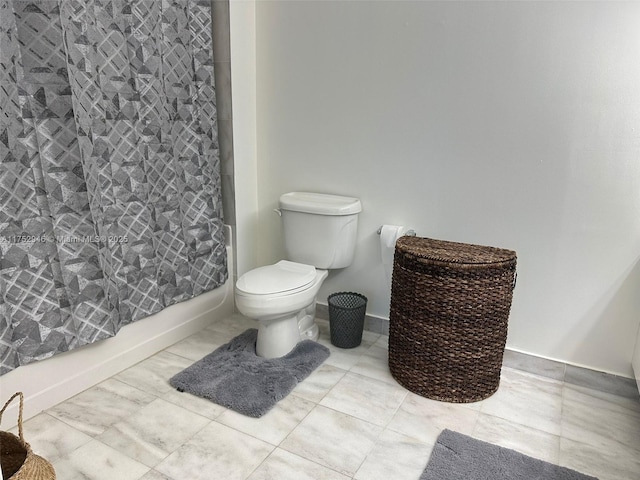 bathroom featuring shower / tub combo with curtain and toilet
