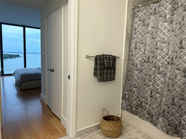 corridor with a water view and wood finished floors