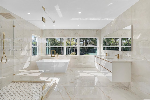 full bath with vanity, tile walls, marble finish floor, a soaking tub, and a marble finish shower