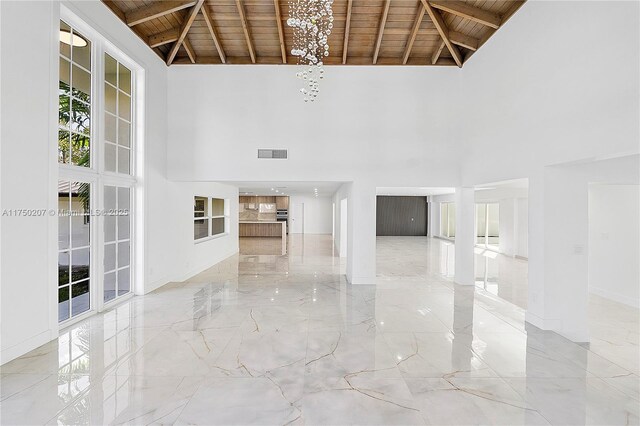 unfurnished living room featuring marble finish floor, wood ceiling, visible vents, and beamed ceiling