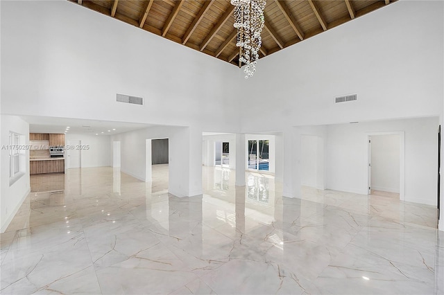 empty room featuring wood ceiling, visible vents, and marble finish floor