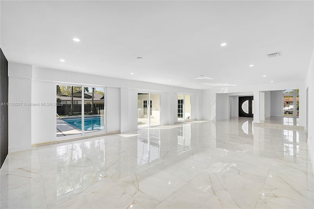 unfurnished living room with marble finish floor, visible vents, and recessed lighting