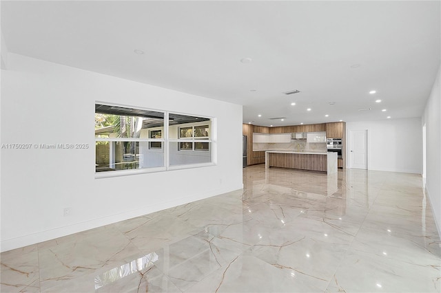 unfurnished living room featuring recessed lighting, marble finish floor, and baseboards