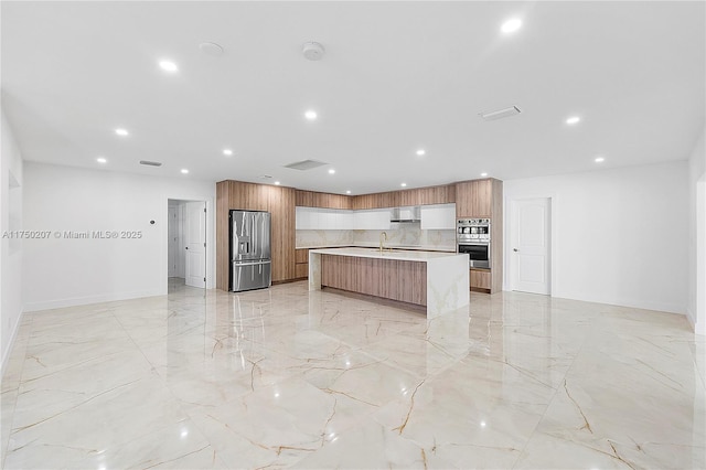 kitchen featuring modern cabinets, appliances with stainless steel finishes, brown cabinets, and light countertops