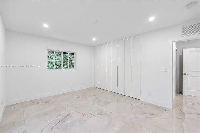 spare room with recessed lighting, marble finish floor, visible vents, and baseboards