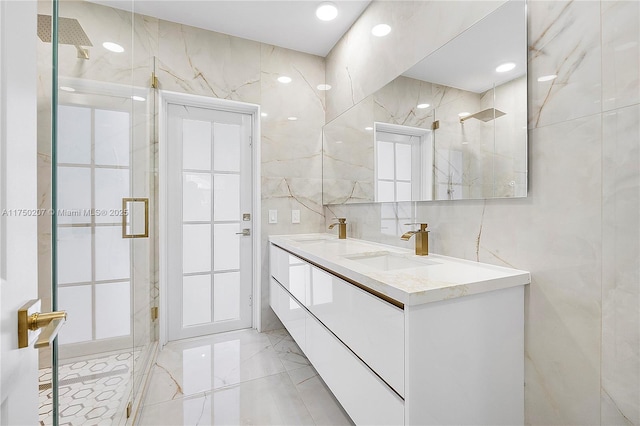 full bath with marble finish floor, a sink, tile walls, and a marble finish shower