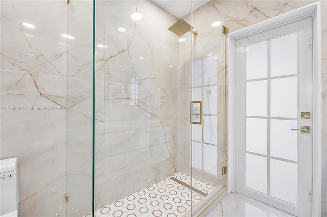 bathroom featuring a marble finish shower