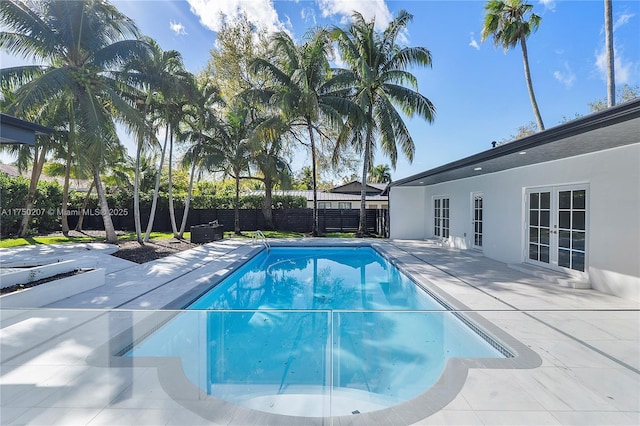 view of pool with a fenced in pool, a patio area, french doors, and a fenced backyard