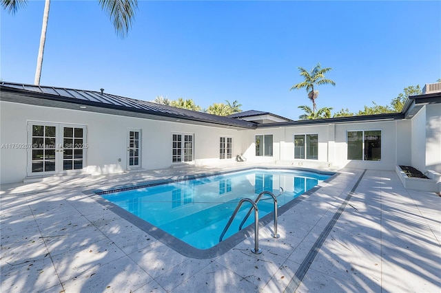 outdoor pool featuring french doors and a patio area