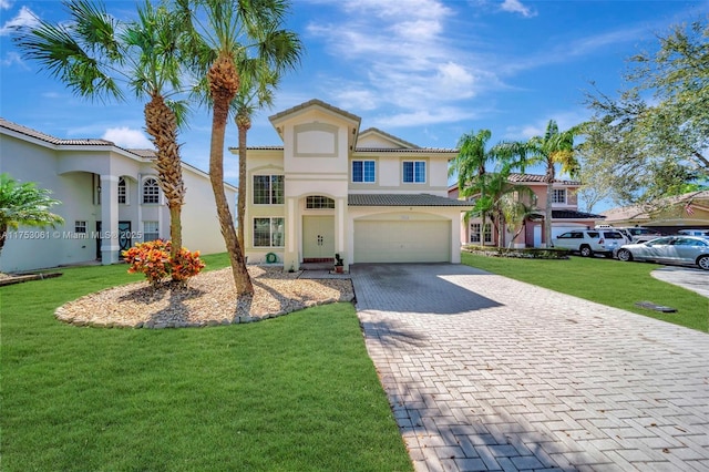 mediterranean / spanish house featuring decorative driveway, stucco siding, a garage, a tiled roof, and a front lawn