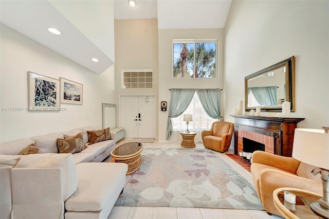 living room featuring a high ceiling, a brick fireplace, tile patterned flooring, and recessed lighting