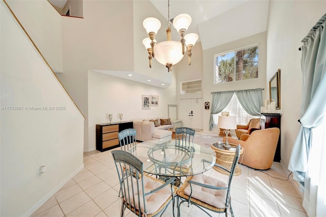 dining room with baseboards, light tile patterned flooring, a towering ceiling, and a notable chandelier