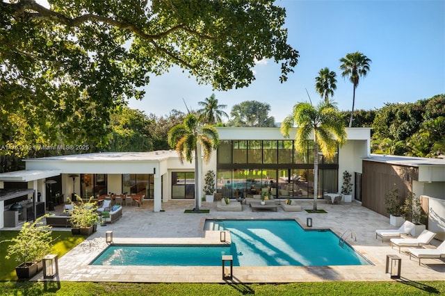 back of property featuring an outdoor pool and a patio