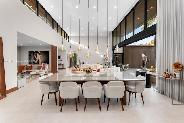 dining area featuring a towering ceiling and recessed lighting