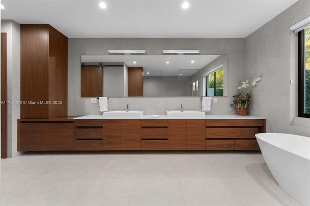 full bath with recessed lighting, a soaking tub, a sink, and double vanity