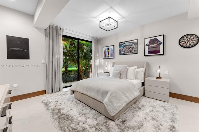 bedroom with baseboards, tile patterned flooring, and access to exterior