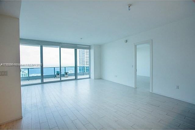 spare room featuring light wood-style flooring and floor to ceiling windows