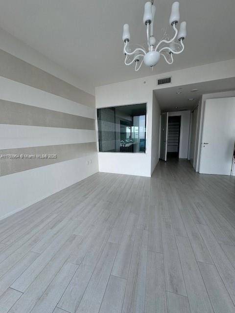 interior space with a chandelier, visible vents, and wood finished floors