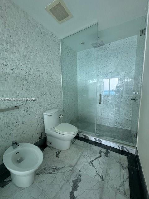 full bath featuring marble finish floor, visible vents, a shower stall, and a bidet