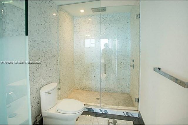 bathroom with a shower stall and toilet