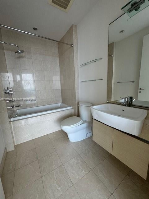 full bathroom featuring tile patterned flooring, toilet, tiled shower / bath combo, vanity, and visible vents