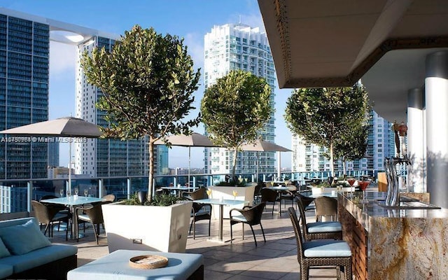 view of patio featuring a balcony, outdoor dry bar, a city view, and an outdoor living space