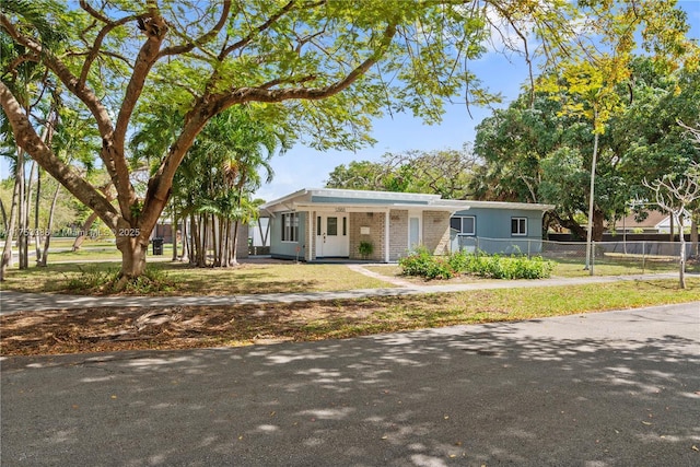 single story home featuring fence, a front lawn, and brick siding