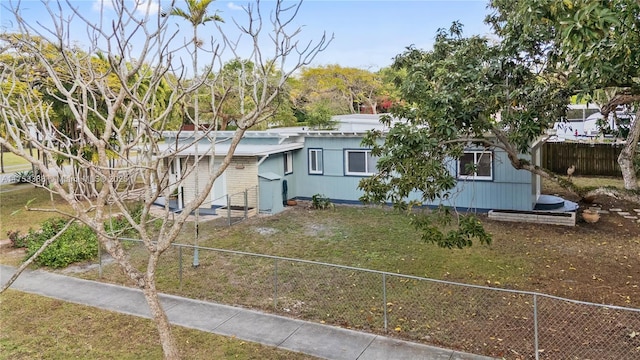 view of front of house featuring fence private yard and a front lawn